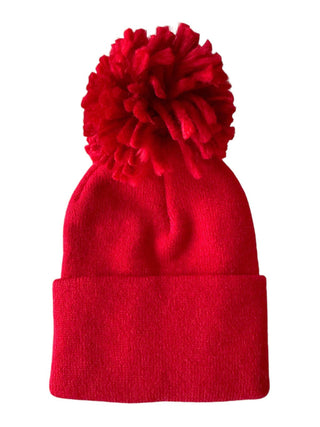 The SpearmintLOVE Babys First Hat in festive red features a large pom-pom, soft and stretchy knit fabric, and a stylish folded brim.