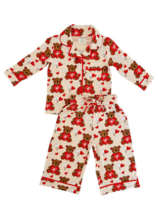 The SpearmintLOVE Lounge Set - Valentine Bear for children features a beige background with red flowers and brown bears. It includes a long-sleeved shirt with black piping and matching pants, ideal for family matching moments.